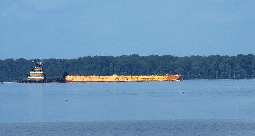 A tug boat pushing a barge on the St. Johns River.
