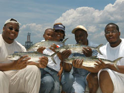 Family holding spanish mackerel